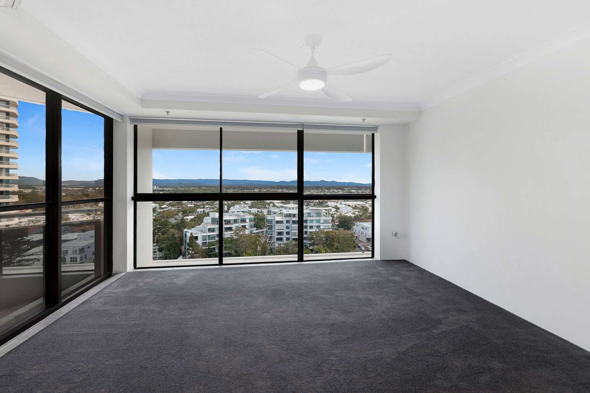 Carpeted bedroom with a ceiling fan and wide windows